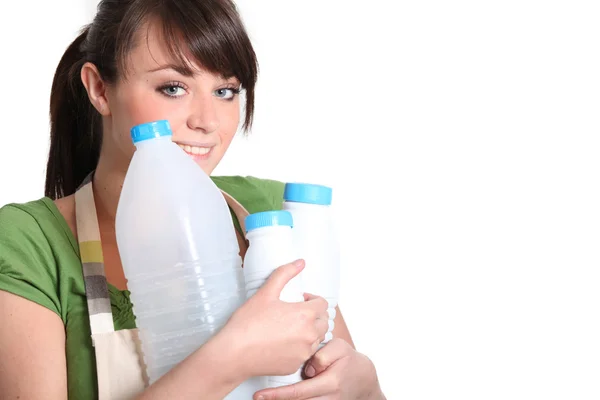 Młoda kobieta prowadzenie puste butelki mleka — Zdjęcie stockowe