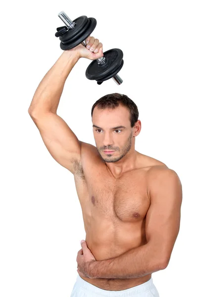 Hombre de pecho desnudo hombre musculoso de 30 años haciendo ejercicio con mancuerna —  Fotos de Stock