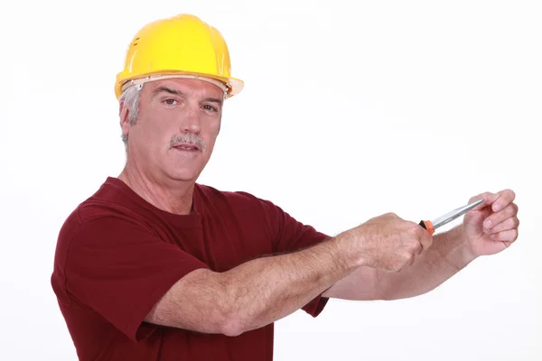 Grey haired man using screw driver — Stock Photo, Image