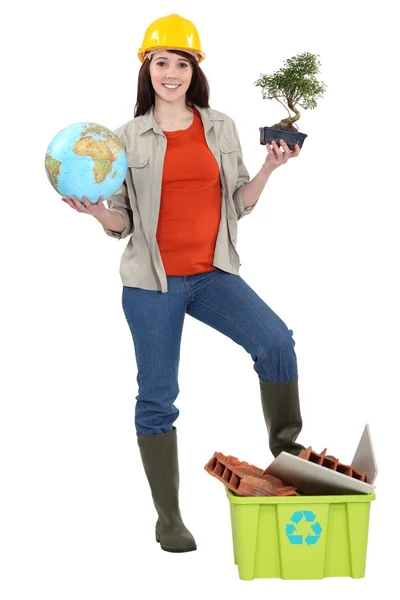 Süße brünette Lehrling hält Globus mit Fuß auf Recycling-Wanne — Stockfoto