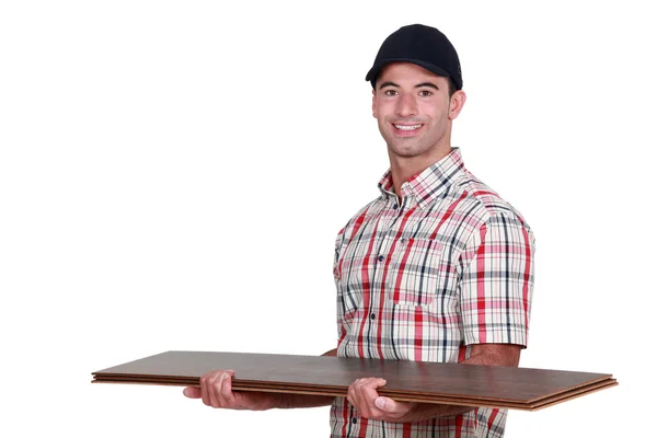 Řemeslník drží pár podlahové desky — Stock fotografie