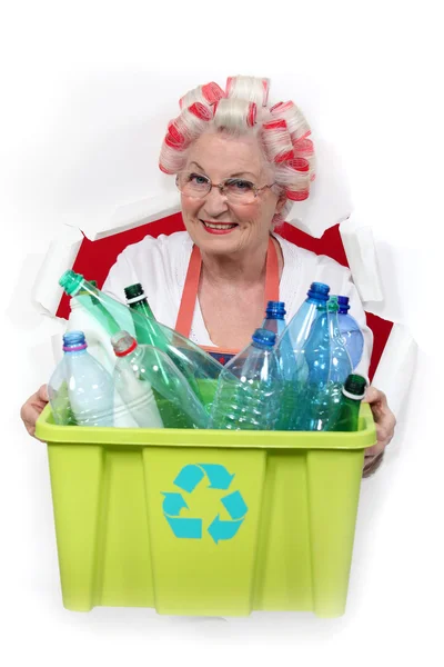 Mamie avec boucles de cheveux tenant baignoire de recyclage pleine de bouteilles en plastique — Photo