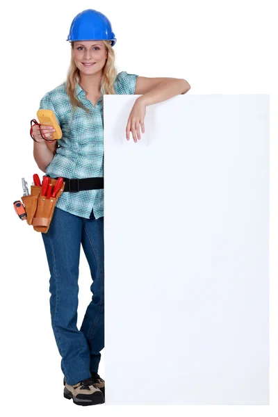 Eletricista feminino de pé com placa de publicidade — Fotografia de Stock
