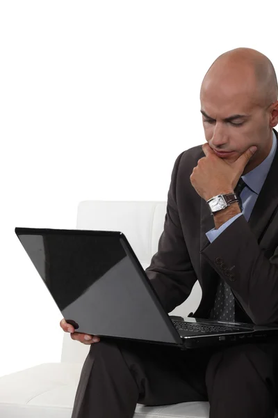 Zamyślony łysy mężczyzna za pomocą laptopa — Zdjęcie stockowe