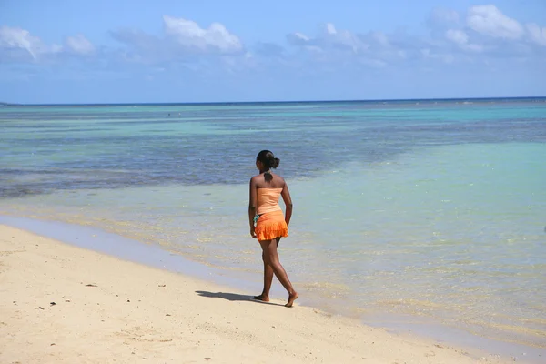 Женщина, идущая вдоль пляжа — стоковое фото