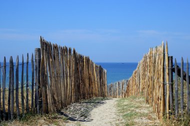 Wooden fencing along a beach clipart