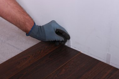 Man installing parquet flooring clipart