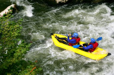 Two kayaking down river rapids clipart