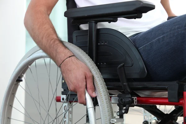 Closeup of a man's hand on the wheel of his wheelchair — Stock Photo, Image
