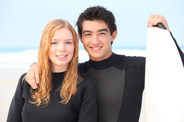 Young couple stood with surfboard — Stock Photo, Image