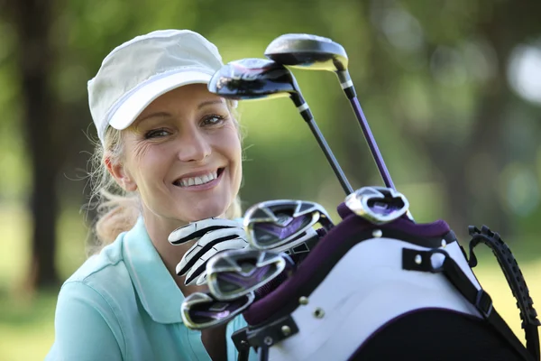 Mulher com um saco cheio de tacos de golfe — Fotografia de Stock