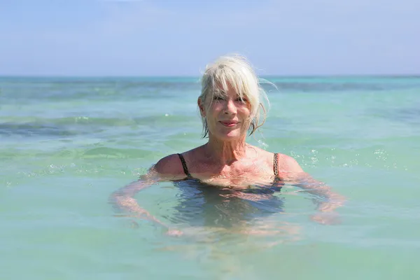 Femme âgée nageant dans la mer — Photo