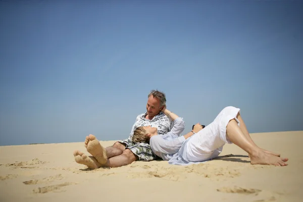 Paar leggen in het zand — Stockfoto
