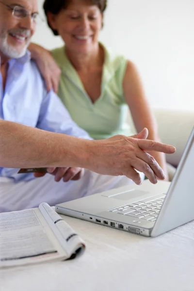 Äldre par med en bärbar dator — Stockfoto