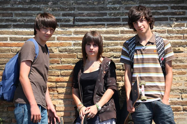 Подростки, прислонившиеся к стене — стоковое фото