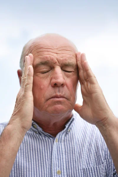 Hombre mayor sufriendo de dolor de cabeza — Foto de Stock