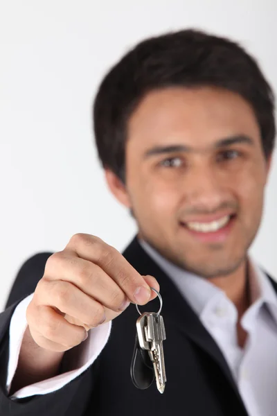 Уверенный в себе агент по недвижимости, вручающий ключи — стоковое фото