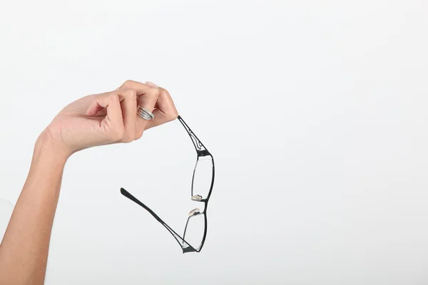 Studio împușcat de o mână ținând o pereche de ochelari — Fotografie, imagine de stoc