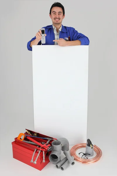 Klempner mit Werkzeug zeigt Handy — Stockfoto