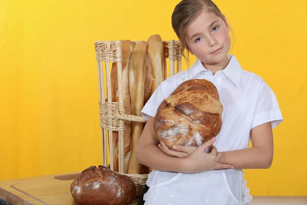 Маленькая девочка печет хлеб — стоковое фото