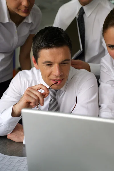 Equipe de negócios olhando para um laptop — Fotografia de Stock