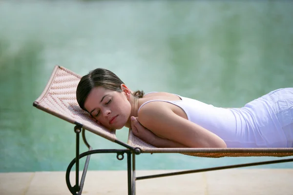 Frau schläft an einem Pool — Stockfoto