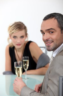 Successful couple toasting with champagne clipart