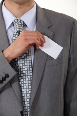 A cropped picture of a businessman putting his card in his pocket. clipart