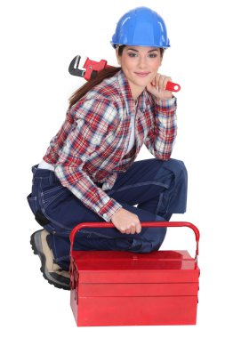 Portrait of a tradeswoman with a pipe wrench and a toolbox clipart