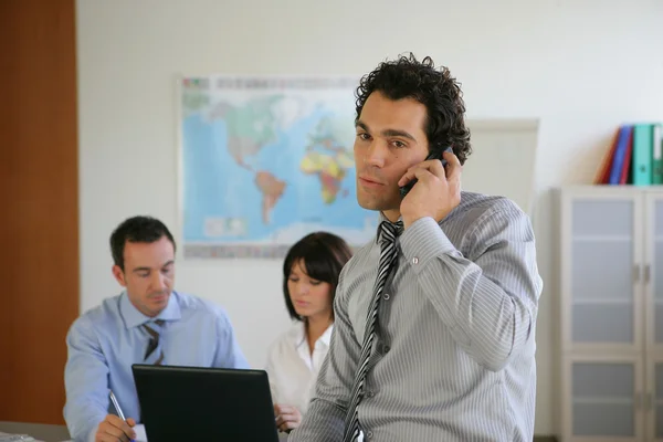 Mann telefoniert mit Kollegen im Hintergrund — Stockfoto