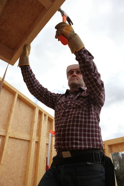 Builder putting up a wooden house — Stock Photo, Image