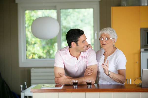 Volwassen man met zijn moeder in een keuken — Stockfoto