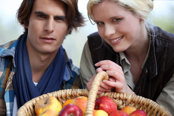 Casal com cesta de maçãs — Fotografia de Stock