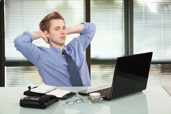 Young employee relaxing in office — Stock Photo, Image