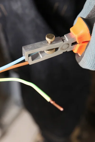 Elektricien knippen de uiteinden van elektrische draden — Stockfoto