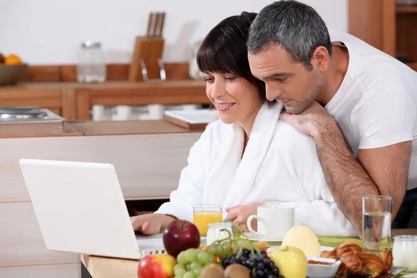 Пара завтракает вместе во время просмотра интернета — стоковое фото