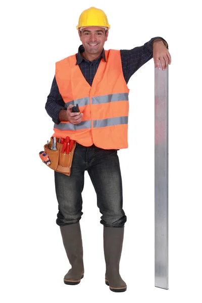 Portrait of carpenter all smiles with arm resting on metallic post — Stock Photo, Image