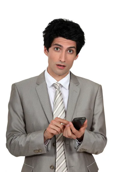 Wide-eyed businessman sending a text message — Stock Photo, Image