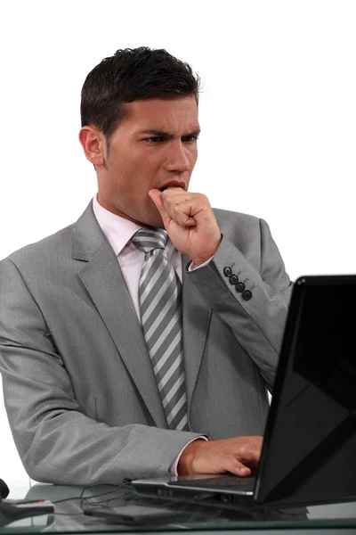 Affärsman tittar på sin laptop och äta sin knytnäve — Stockfoto