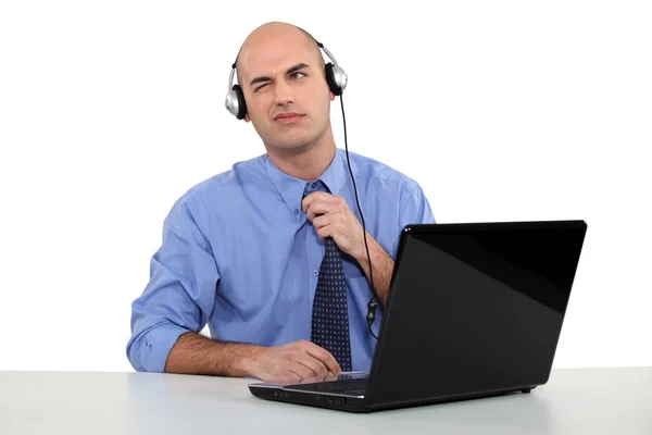 자신의 노트북 앞에서 헤드폰을 착용 하는 남자 — 스톡 사진