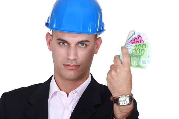 Een mannelijke architect met zijn hand vol van contant geld. — Stockfoto