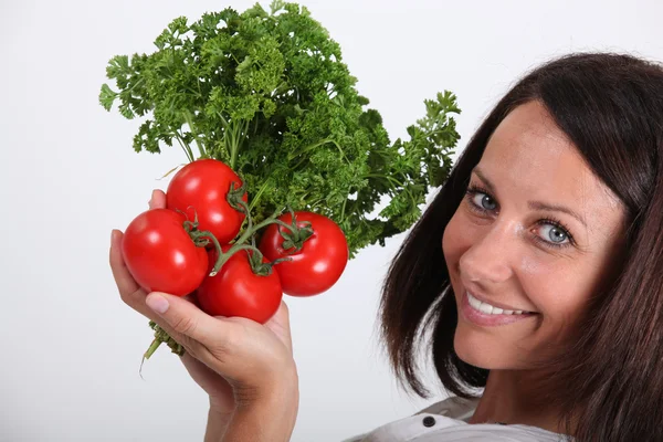 Mujer sosteniendo racimo de tomates — Foto de Stock