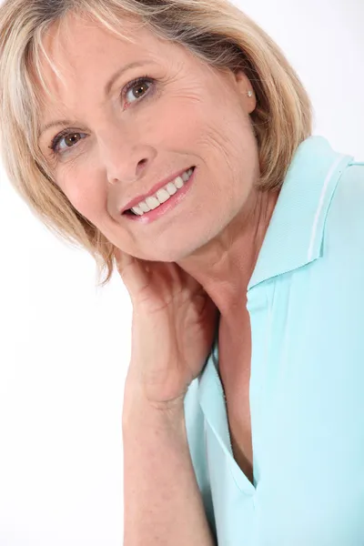 Rijpe blonde vrouw het dragen van een turquoise polo shirt met een grote glimlach — Stockfoto