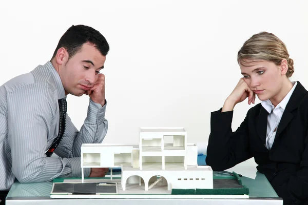 Két lélektelen építészek leült ház modell — Stock Fotó