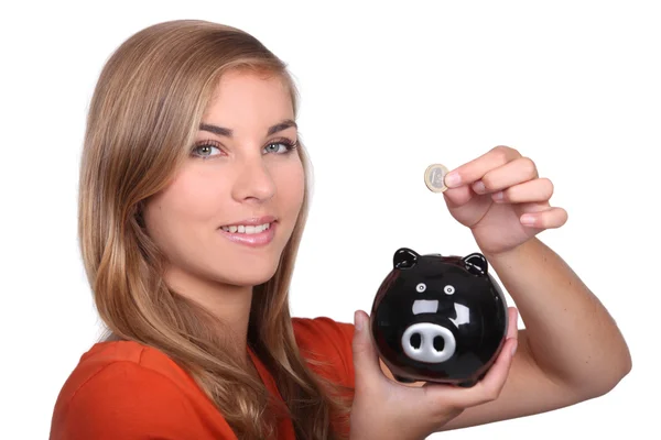 Teenage girl holding coin and piggy bank — Stock Photo, Image