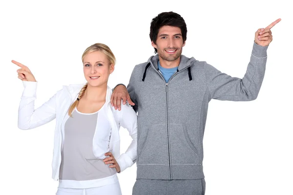 Happy couple training together pointing at different directions — Stock Photo, Image