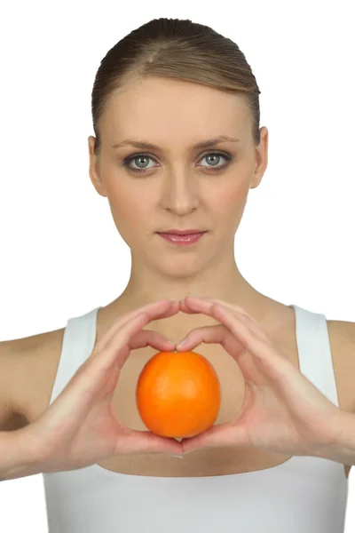 Mujer sosteniendo una naranja — Foto de Stock