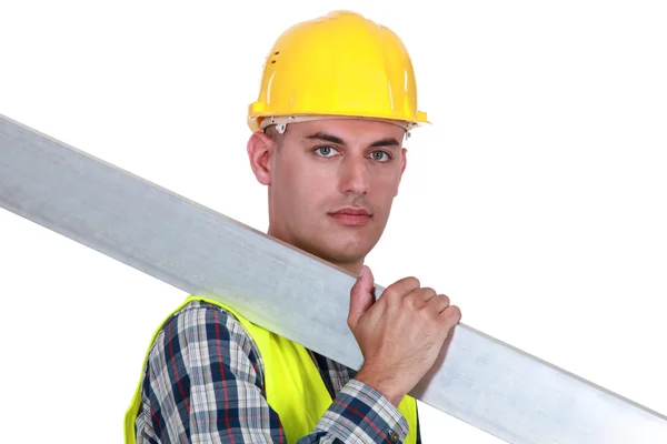 En byggnadsarbetare bära stål planka. — Stockfoto