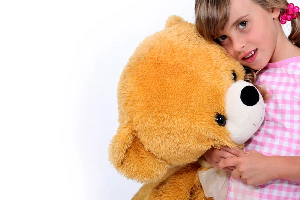Маленька дівчинка обіймає плюшевого ведмедя — стокове фото