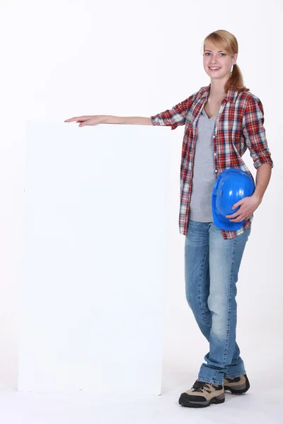 Vrouwelijke bouwvakker met een leeg bord — Stockfoto